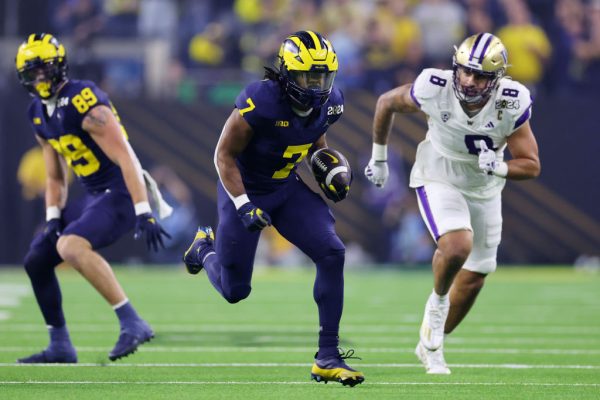 HOUSTON, TEXAS - JANUARY 08: Donovan Edwards #7 of the Michigan Wolverines runs the ball for a touchdown in the first quarter  against the Washington Huskies during the 2024 CFP National Championship game at NRG Stadium on January 08, 2024 in Houston, Texas. (Photo by Stacy Revere/Getty Images)
